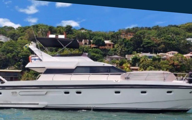 Intermarine 50 em enseada com casas na encosta